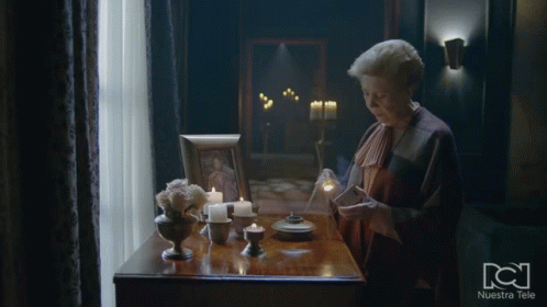 Woman at Table With Candles and Nuestra Tele Frame