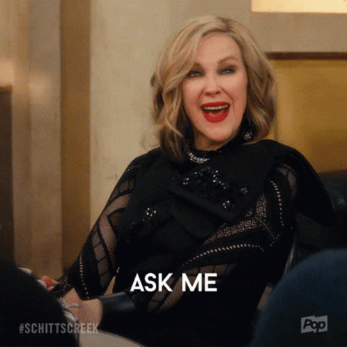 Woman at Table With Mouth Open and Ask Me Behind Her