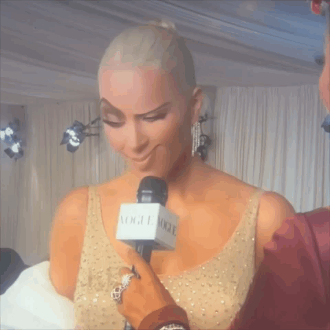 Woman Being Interviewed by Man with Vogue Microphone