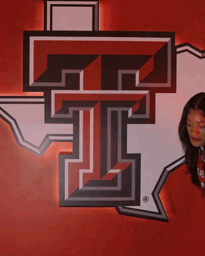 Woman Beside Large T on Red