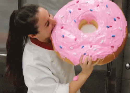 Woman Biting Giant Pink Donut with Sprinkles