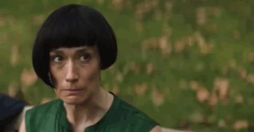 Woman Biting Nails In Front Of Trees GIF