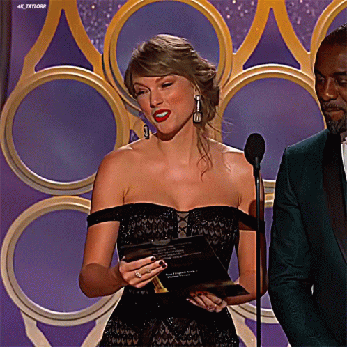 Woman Black Dress at Microphone, Man Green Suit