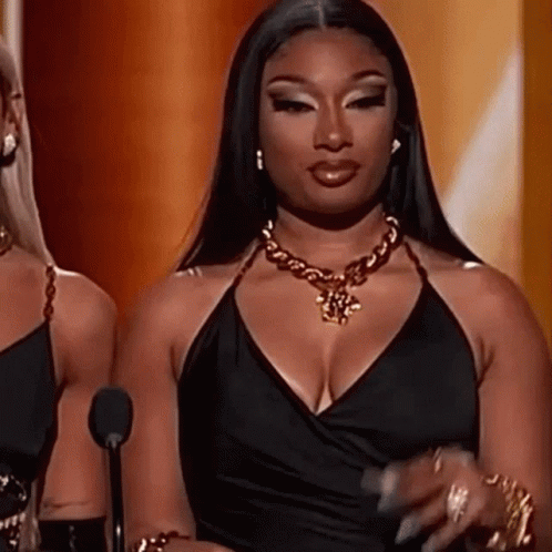Woman Black Dress At Microphone With Gold Necklace GIF