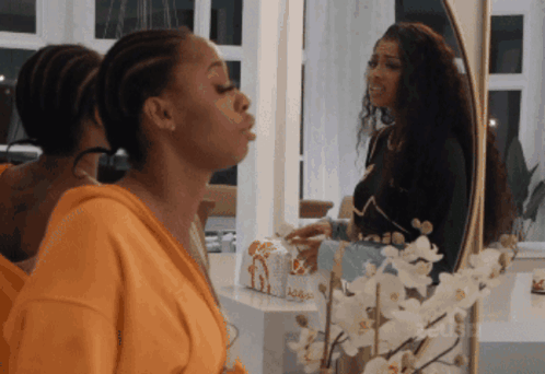 Woman Blowing Kiss In Front Of Mirror With Flowers GIF
