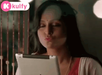 Woman Blowing Kiss Looking At Tablet GIF