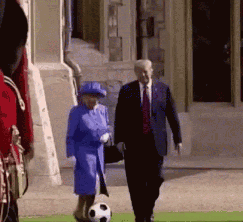Woman Blue Coat with Soccer Ball Next to Man Suit Tie