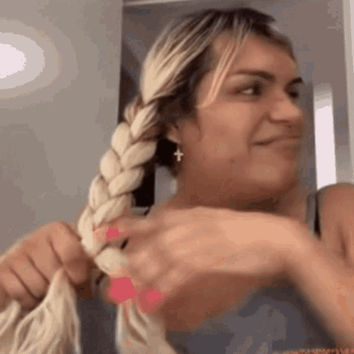 Woman Braiding Hair Into Ponytail