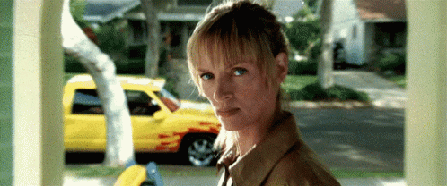 Woman By Yellow Truck Looking At Camera GIF