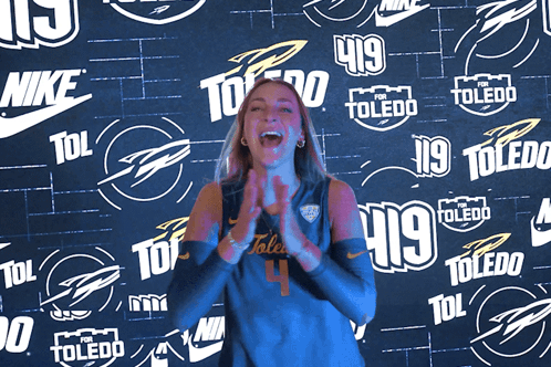 Woman Clapping in Front of Nike Toledo Wall
