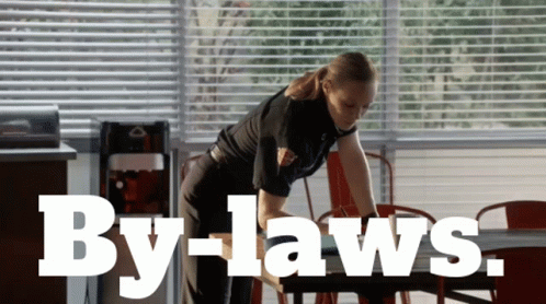 Woman Cleaning Table with By-laws