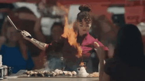 Woman Cooking on Grill with Flames from Hands