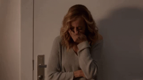 Woman Covering Face in Front of Door