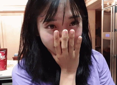 Woman Covering Mouth in Front of Nuggets Bag