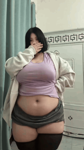 Woman Covering Mouth in Purple Tank Top