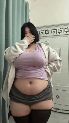 Woman Covering Mouth in Purple Top