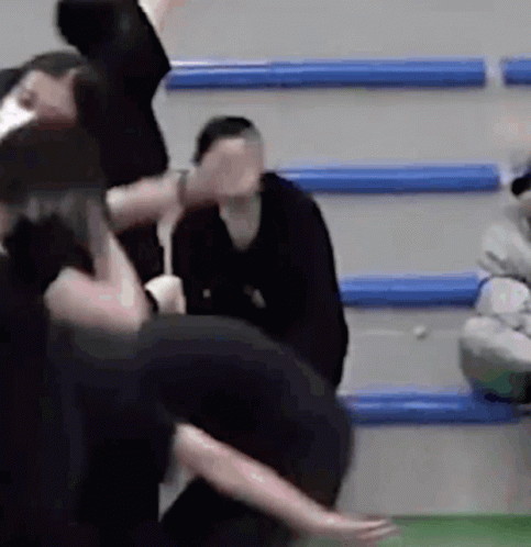 Woman Covers Face, Group Dances in Gym