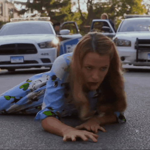 Woman Crawling in Front of Police Car