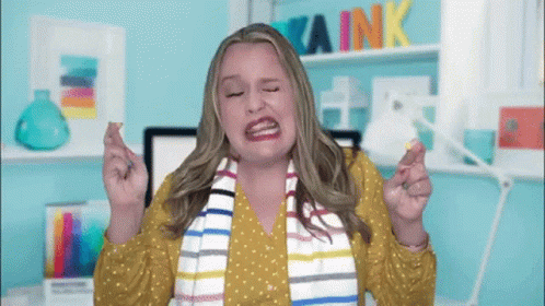 Woman Crosses Fingers In Front Of Wall GIF