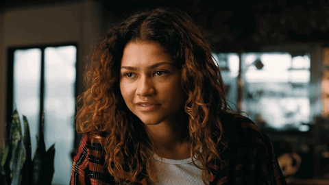 Woman Curly Hair Plaid Shirt Looks at Camera