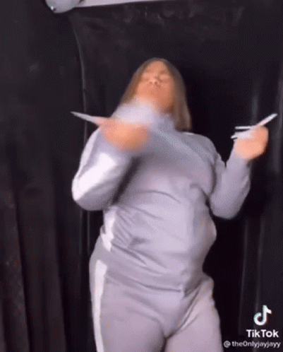 Woman Dancing Holding Paper in Front of Black Curtain