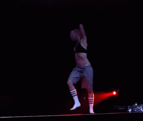 Woman Dancing In Black Bra And Grey Shorts On Stage GIF