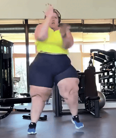 Woman Dancing in Gym Wearing Shorts and Yellow Tank Top