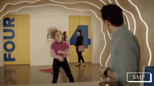 Woman Dancing in Hallway With Sign Saying Four