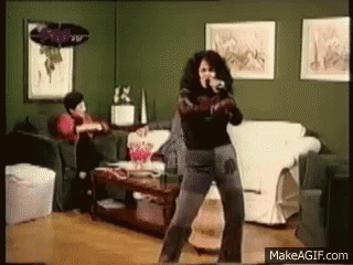 Woman Dancing in Living Room Man Sitting on Couch