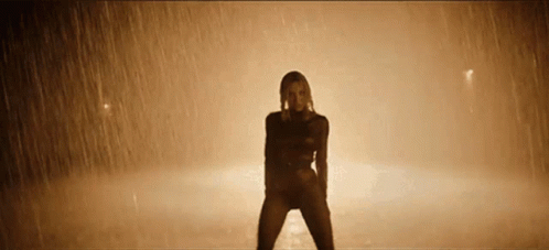 Woman Dancing in Rain in Dimly Lit Room