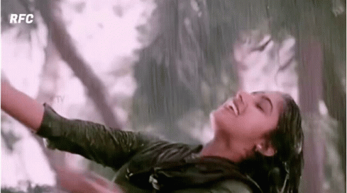Woman Dancing in Rain With Arms Outstretched Smiling