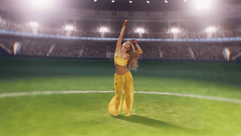 Woman Dancing on Soccer Field With Arms in Air