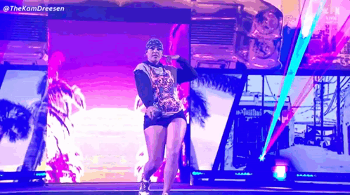Woman Dancing On Stage In Front Of Screen With Palm Trees GIF
