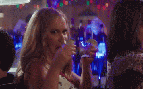 Woman Drinking and Eating Taco in Bar