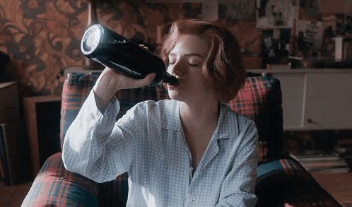 Woman Drinking From Bottle in Plaid Chair