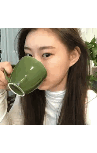Woman Drinking from Green Mug