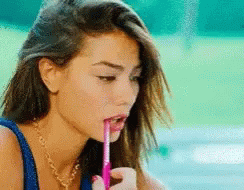 Woman Drinking from Pink Straw with Pen