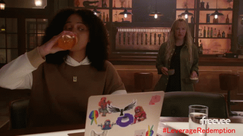 Woman Drinking Orange Juice Next To Laptop GIF