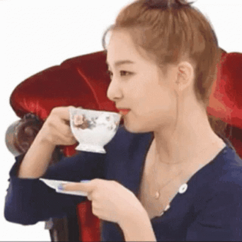 Woman Drinking Tea in Red Chair