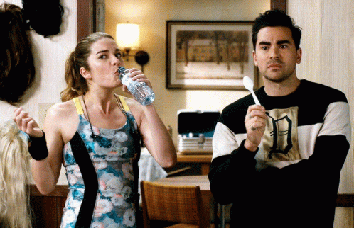 Woman Drinking Water Next to Man With Spoon