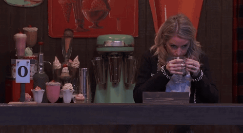 Woman Drinks From Glass Under 0 Degrees Sign GIF