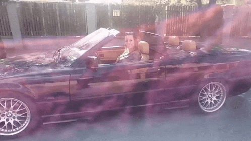 Woman Driving Black Convertible With Purple Smoke GIF