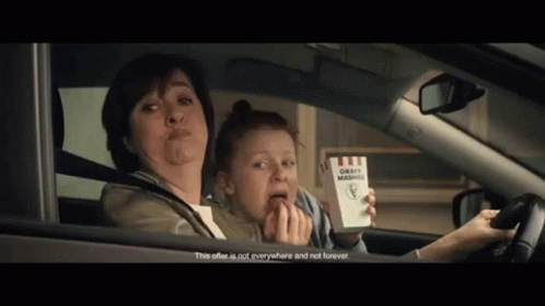 Woman Driving Car With Child Holding Box of Gravy Mashed Potatoes