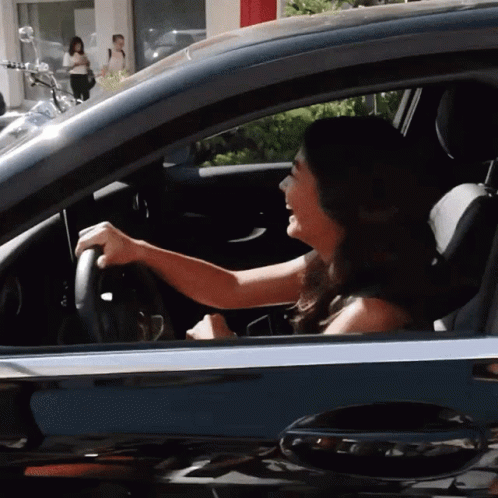 Woman Driving Car With Motorcycle Parked Behind
