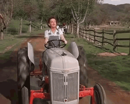 Woman Driving Tractor on Dirt Road