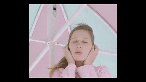 Woman Ear Plugs While Singing GIF