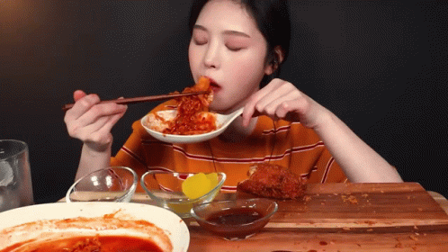 Woman Eating Food With Chopsticks And Sauce GIF