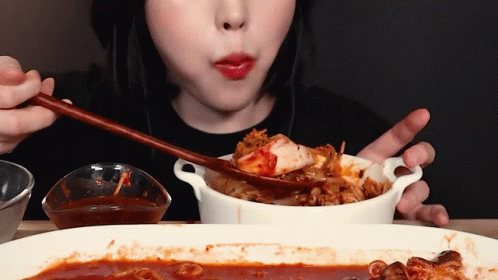 Woman Eating Food With Chopsticks and Spoon