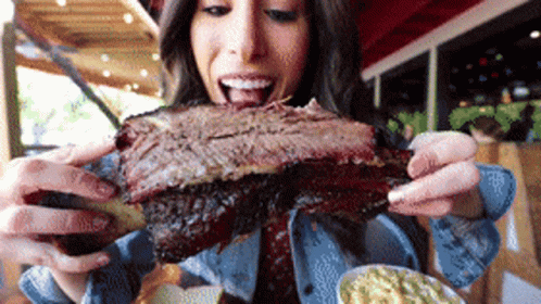 Woman Eating Huge Piece of Meat