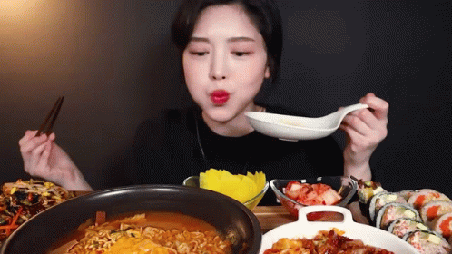Woman Eating Ramen And Sushi With Chopsticks And Spoon GIF